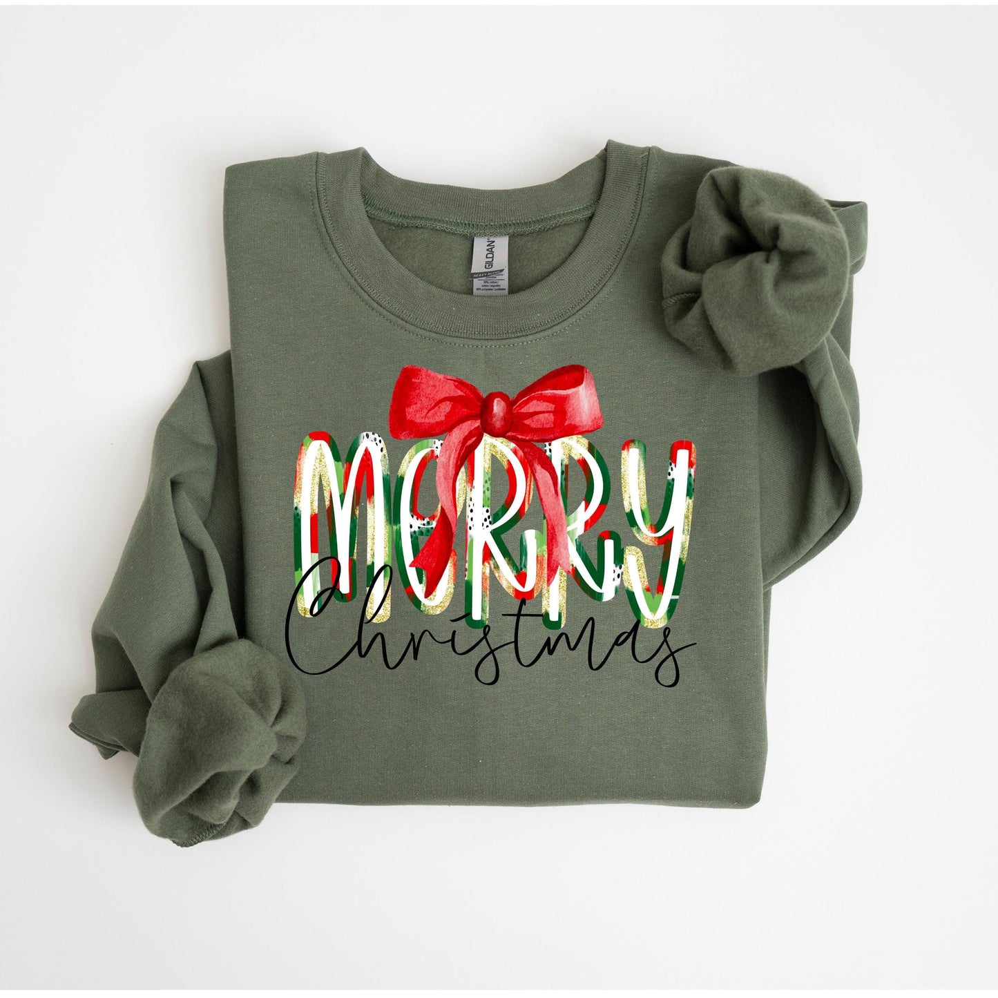 Olive green sweatshirt with the words “Merry Christmas” in red, white, and green letters topped with a red bow — festive holiday sweatshirt perfect for Christmas celebrations.