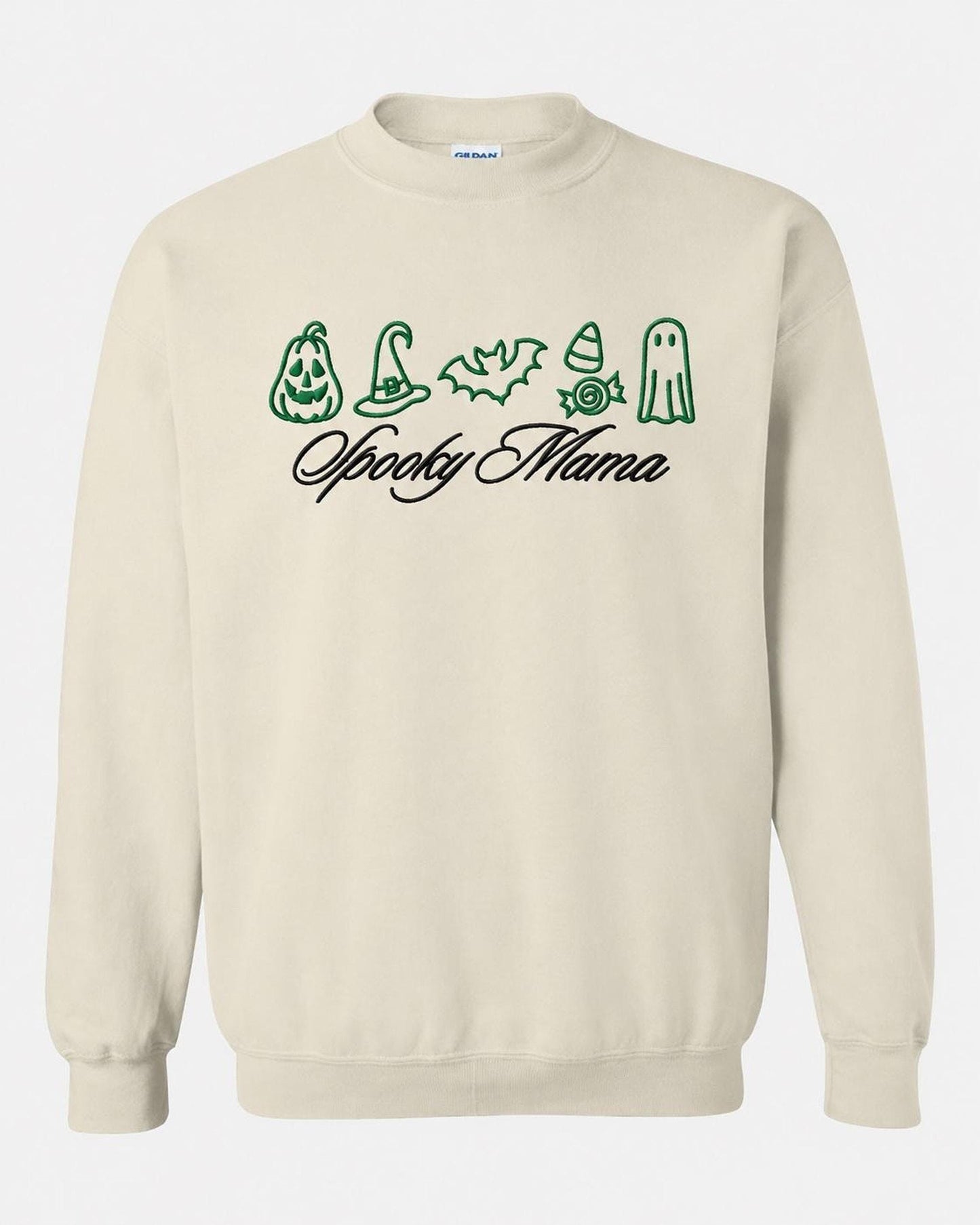 A light beige crewneck sweatshirt with green embroidered Halloween icons and "Spooky Mama" in black script, displayed flat against a white background.