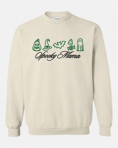 A light beige crewneck sweatshirt with green embroidered Halloween icons and "Spooky Mama" in black script, displayed flat against a white background.